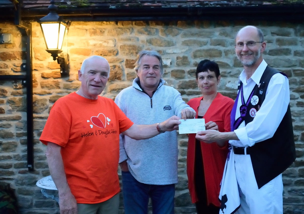 From right to left, The Squire, Karen, and Phil present a cheque to Peter West of Helen & Douglas House.